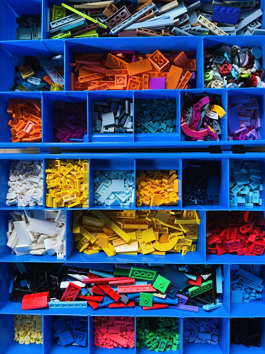 Bins of LEGO pieces sorted by color in the studio