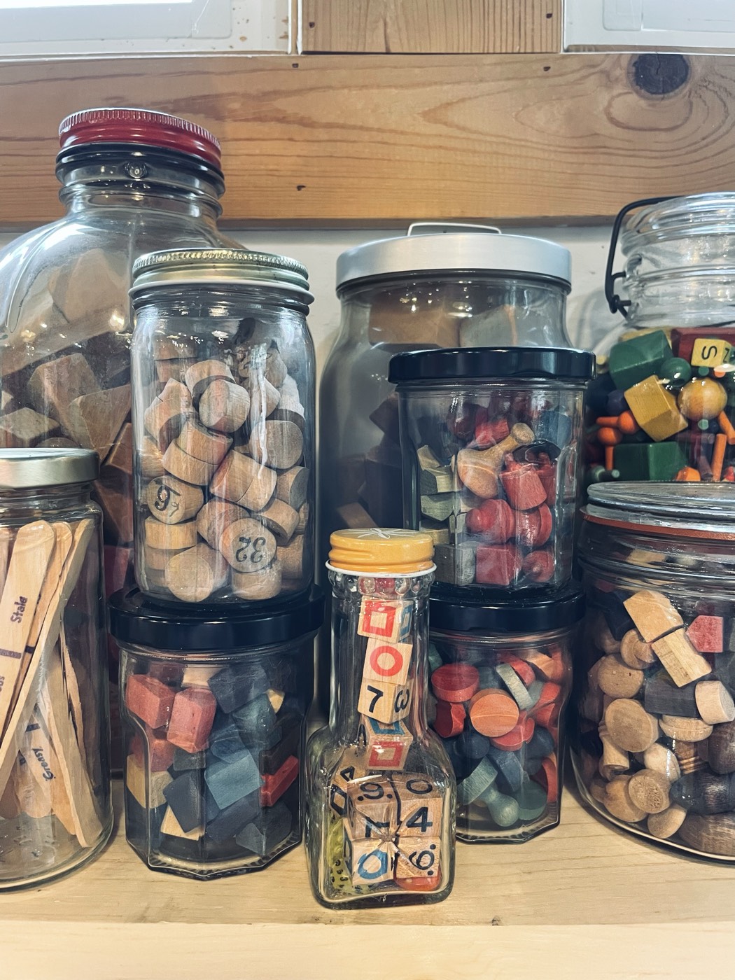Jars of wooden game pieces on a shelf in the studio
